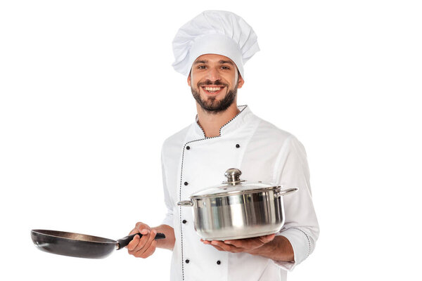 Улыбающийся шеф-повар в униформе держит сковородку и сковородку изолированы на белом
