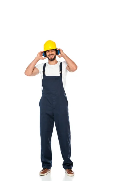 Χαμογελώντας Εργάτης Hardhat Και Υπερασπιστές Των Αυτιών Κοιτάζοντας Κάμερα Λευκό — Φωτογραφία Αρχείου