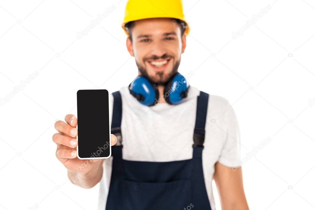 Selective focus of smiling workman showing smartphone with blank screen isolated on white