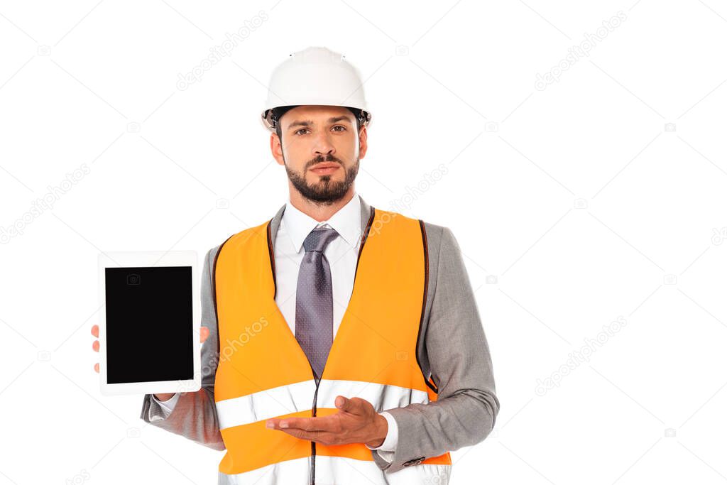 Engineer in suit and safety helmet pointing with hand at digital tablet isolated on white