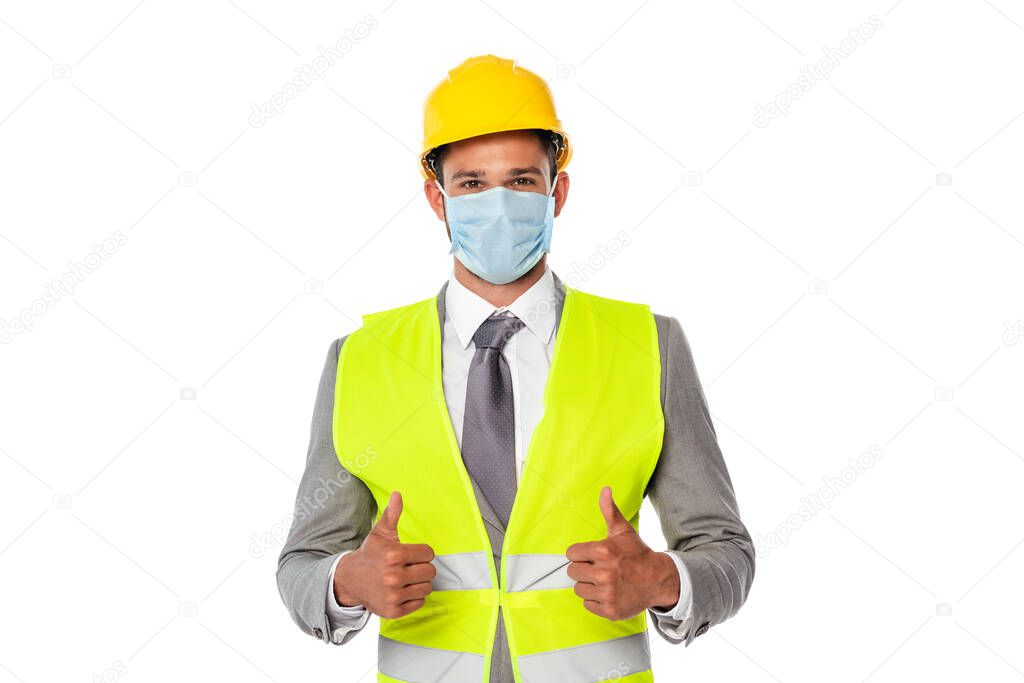 Engineer in hardhat and medical mask showing thumbs up isolated on white