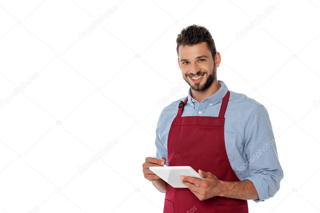 Smiling waiter looking at camera while using digital tablet isolated on white