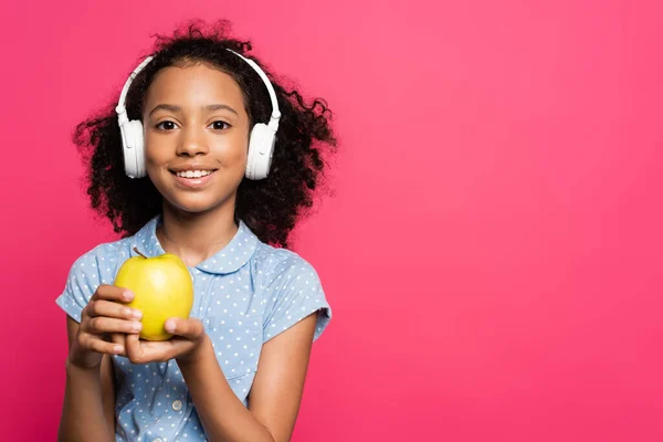 분홍색으로 사과를 헤드폰을 곱슬머리 아프리카계 미국인 아이가 — 스톡 사진