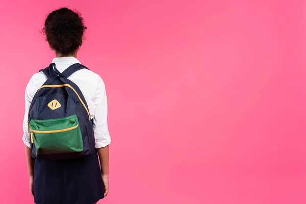 back view of african american schoolgirl with backpack isolated on pink