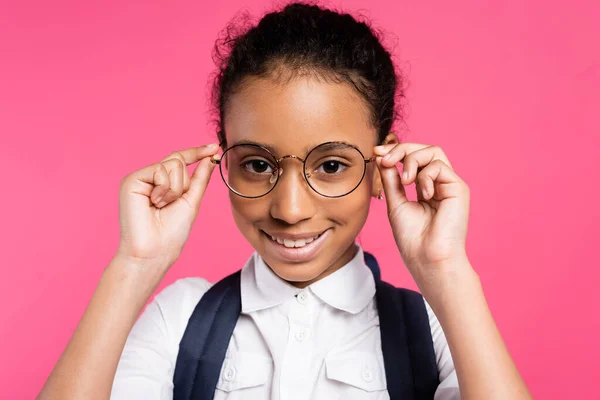 Χαμογελαστή Αφροαμερικανίδα Μαθήτρια Που Προσαρμόζει Γυαλιά Απομονωμένα Ροζ — Φωτογραφία Αρχείου