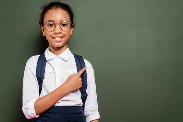 Glimlachend Afrikaans Amerikaans Schoolmeisje Wijzend Naar Leeg Groen Schoolbord — Stockfoto