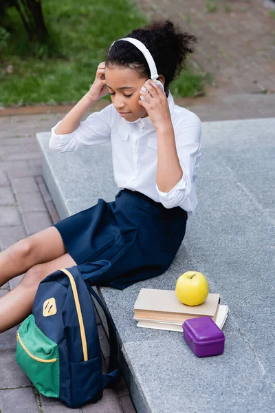 Αφροαμερικανή Μαθήτρια Που Ακούει Μουσική Ακουστικά Κοντά Σακίδιο Βιβλία Και — Φωτογραφία Αρχείου