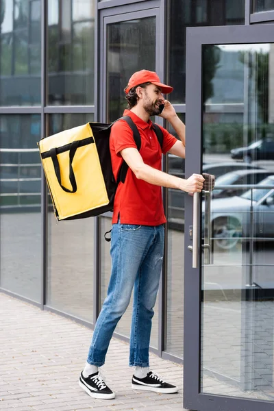 Smiling Delivery Man Talking Smartphone Opening Door Building Urban Street — Stock Photo, Image