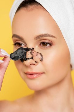 beautiful naked woman with towel on head removing blackheads on nose isolated on yellow clipart