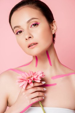 Vücudunda pembe çizgiler ve pembe üzerinde izole kasımpatı olan güzel bir kadın.