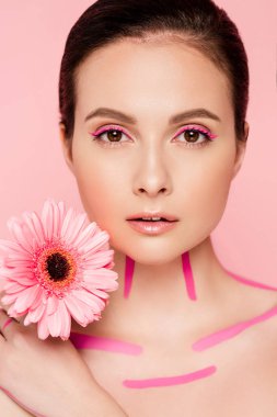 Vücudunda pembe çizgiler ve pembe üzerinde izole edilmiş kasımpatı olan çıplak güzel bir kadın.