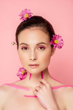 Vücudunda pembe çizgileri olan çıplak güzel bir kadın ve pembe üzerinde izole edilmiş saçları olan çiçekler.