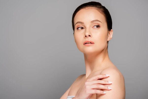 beautiful woman with perfect skin looking away isolated on grey