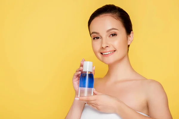 Bella Donna Sorridente Che Tiene Acqua Micellare Bottiglia Isolata Giallo — Foto Stock