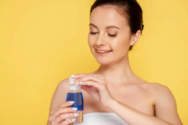 Sonriente Hermosa Mujer Sosteniendo Micelar Agua Botella Aislado Amarillo — Foto de Stock