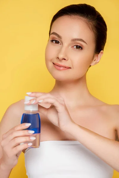 Smiling Beautiful Woman Holding Micellar Water Bottle Isolated Yellow — Stock Photo, Image