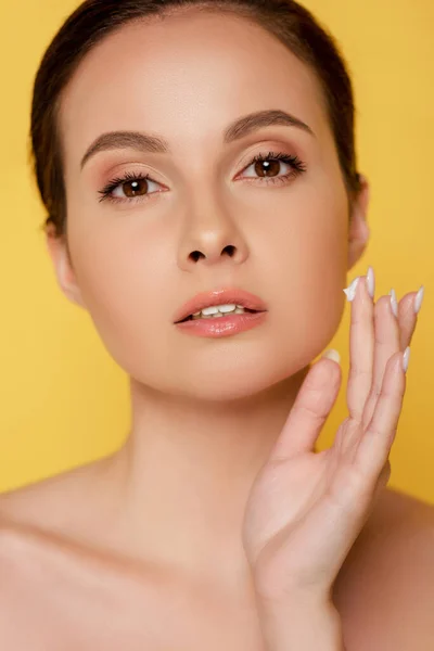 Hermosa Mujer Desnuda Aplicando Crema Facial Aislada Amarillo — Foto de Stock