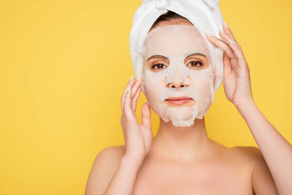 naked beautiful woman with towel on head and face mask isolated on yellow