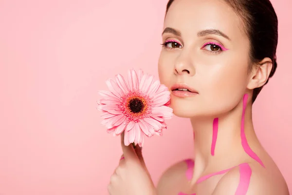 naked beautiful woman with pink lines on body and chrysanthemum isolated on pink