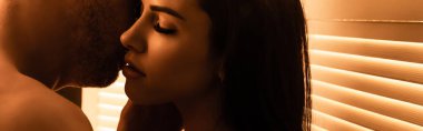 panoramic crop of passionate man kissing sensual woman with closed eyes  clipart