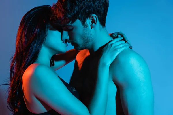 年轻貌美的一对情侣亲吻着拥抱着蓝色 — 图库照片