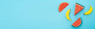 Kağıt karpuz ve muz üst görünümü mavi arka planda, panoramik çekim