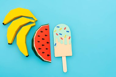 top view of paper watermelon, bananas and ice cream with sprinkles on blue background clipart
