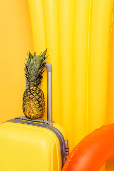 крупным планом дорожная сумка с сосновым яблоком возле бассейна плавает на желтом фоне