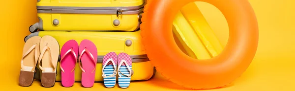 黄色のパノラマショットで家族のフリップフロップとプールフロートを持つ旅行バッグ — ストック写真