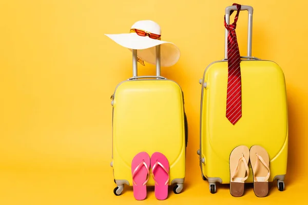 黄色に隔離された男性と女性のアクセサリーを持つ旅行バッグ — ストック写真