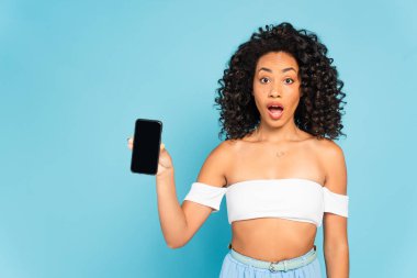 Şok olmuş Afrikalı Amerikalı kız elinde boş ekranlı akıllı telefon tutuyor. 