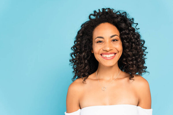 happy african american woman smiling isolated on blue