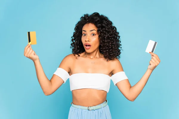 Surprised African American Woman Holding Credit Cards Isolated Blue — Stock Photo, Image