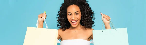 파노라마의 아프리카계 미국인 여성이 쇼핑백을 색으로 웃으며 사진을 찍었다 — 스톡 사진