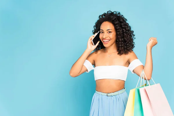 Menina Americana Africana Alegre Falando Smartphone Segurando Sacos Compras Isolados — Fotografia de Stock