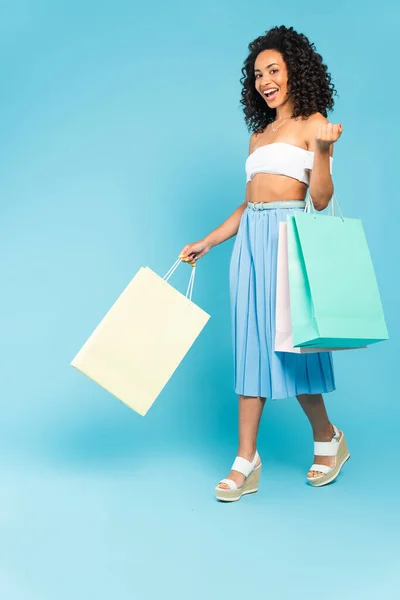 Vrolijk Afrikaans Amerikaans Meisje Holding Shopping Tassen Lopen Blauw — Stockfoto