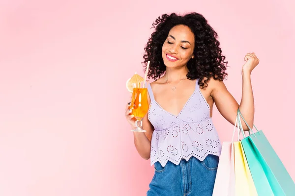 Feliz Afroamericana Chica Sosteniendo Bolsas Compras Mirando Cóctel Aislado Rosa — Foto de Stock