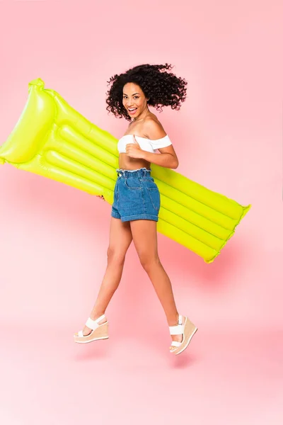 Happy African American Girl Jumping Inflatable Mattress Showing Thumb Pink — Stock Photo, Image