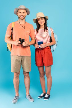 Neşeli adamın yanında elinde pasaportları tutan mutlu bir kız. Mavi dürbünlü adam. 