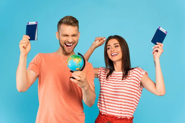 Cheerful Couple Looking Globe While Holding Passports Isolated Blue — Stock Photo, Image