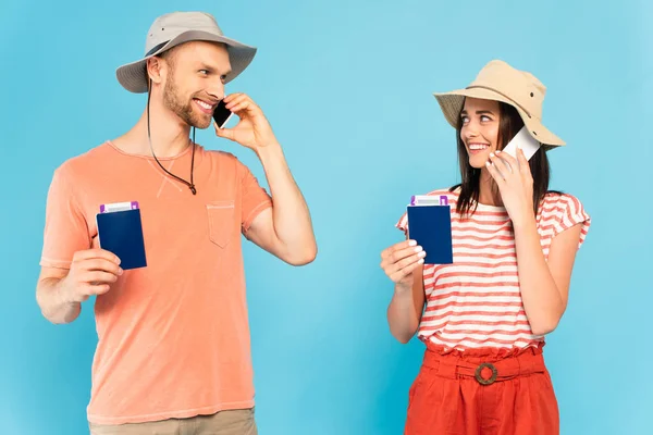 Coppia Felice Cappelli Parlare Smartphone Possesso Passaporti Guardarsi Isolati Blu — Foto Stock