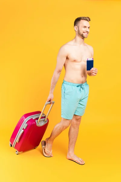 Hombre Feliz Musculoso Con Pasaporte Caminar Con Equipaje Amarillo —  Fotos de Stock