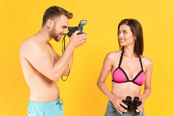 Happy Man Taking Photo Girl Swimsuit Holding Binoculars Isolated Yellow — Stock Photo, Image