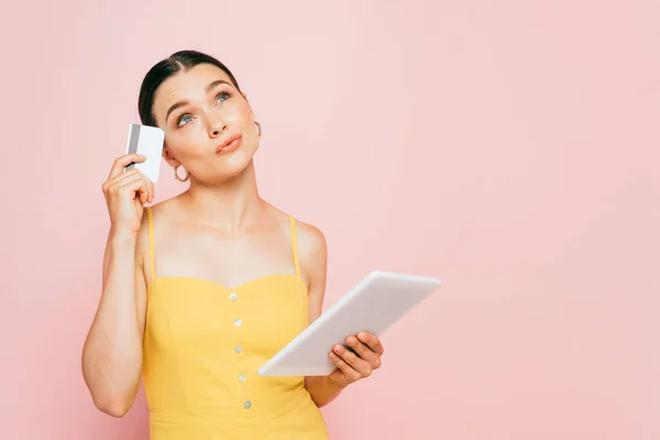 Zamyšlená Brunetka Mladá Žena Digitálním Tabletem Kreditní Kartou Izolované Růžové — Stock fotografie