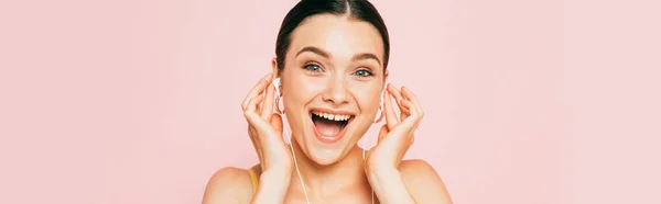 Excitada Morena Joven Escuchando Música Auriculares Aislados Rosa Plano Panorámico —  Fotos de Stock