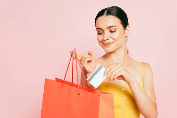 Brunette Young Woman Putting Credit Card Shopping Bag Isolated Pink — Stock Photo, Image