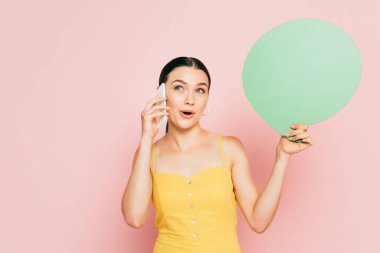 Yeşil, boş konuşma baloncuğu olan esmer bir kadın akıllı telefondan pembe üzerine konuşuyor.