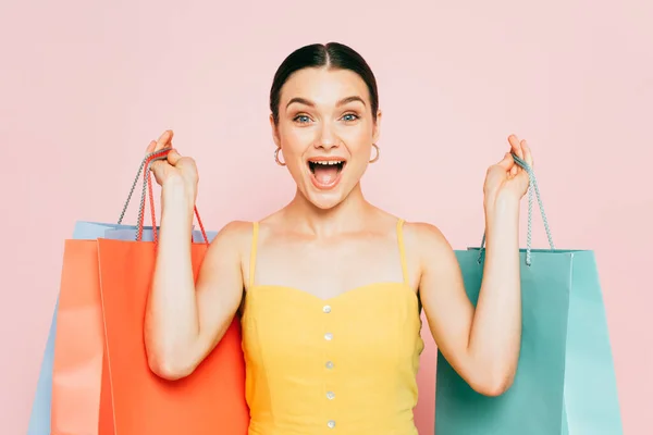 一个兴奋的黑发女子 带着购物袋 与粉色隔离 — 图库照片
