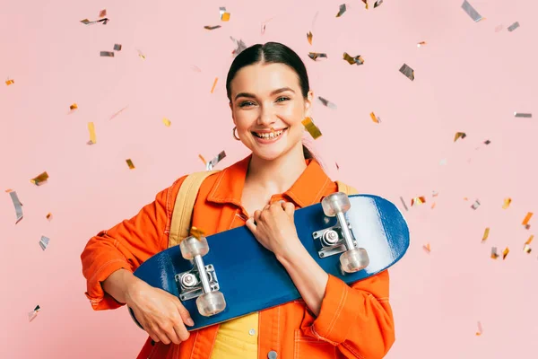 Brunette Young Woman Colorful Outfit Skateboard Falling Confetti Isolated Pink — Stock Photo, Image