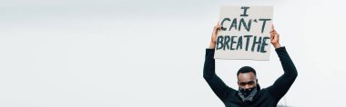 panoramic shot of african american man holding placard with i cant breathe lettering outside  clipart